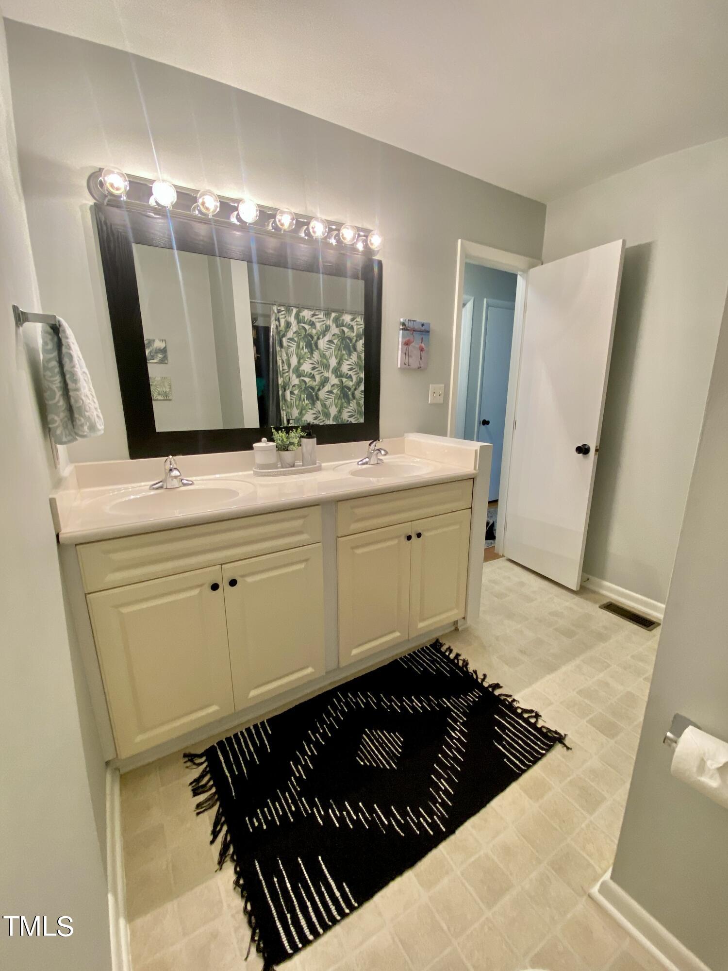 4013 Ingram Drive Raleigh, NC 27604 - Photo 25 of 29 a bathroom with a sink and a mirror