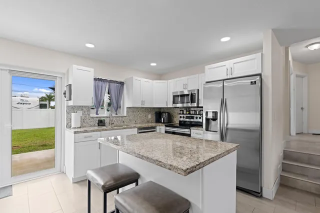 a living room with furniture kitchen view and a wooden floor