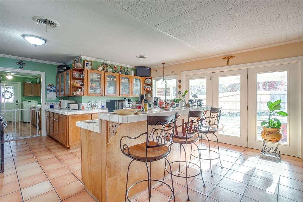 205 West Ridge Street Weatherford, TX 76086 - Photo 11 of 34 a dining hall with stainless steel appliances kitchen island granite countertop a table and chairs in it