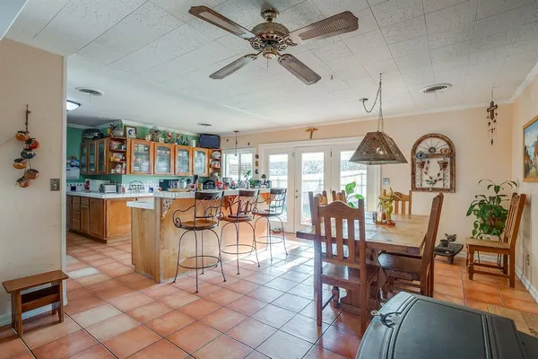 a dining room with furniture a kitchen view and chandelier