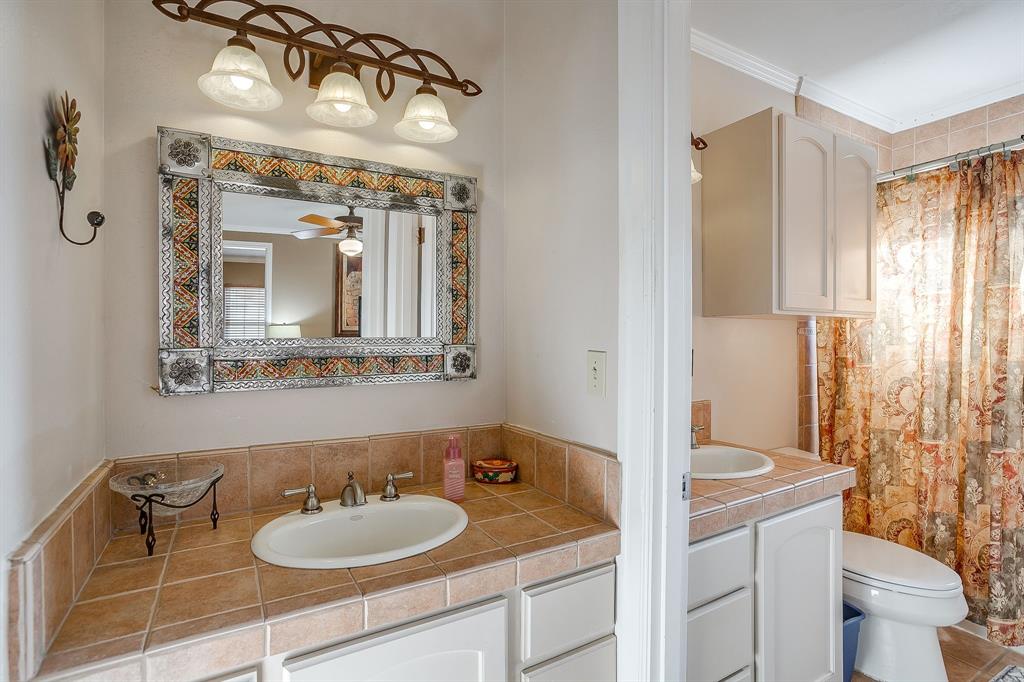 205 West Ridge Street Weatherford, TX 76086 - Photo 20 of 34 a bathroom with a granite countertop sink and a mirror