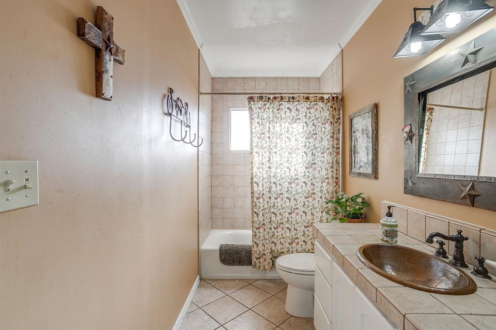 205 West Ridge Street Weatherford, TX 76086 - Photo 27 of 34 a bathroom with a sink a toilet and shower