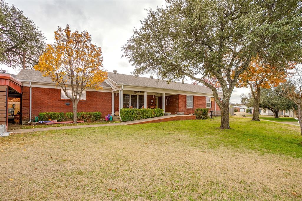 205 West Ridge Street Weatherford, TX 76086 - Photo 3 of 34 a front view of a house with a garden and trees