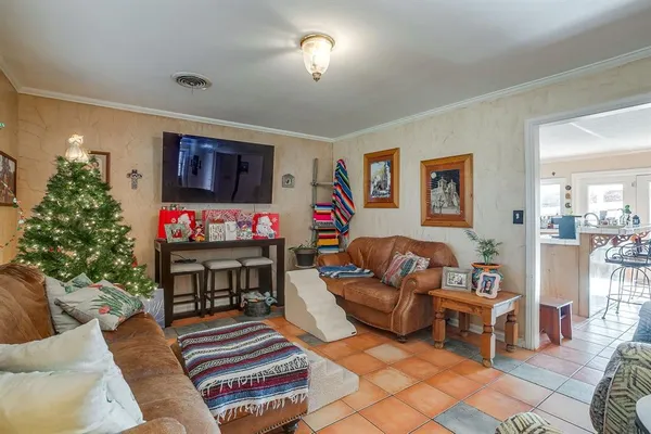 a living room with furniture a flat screen tv and a dining table