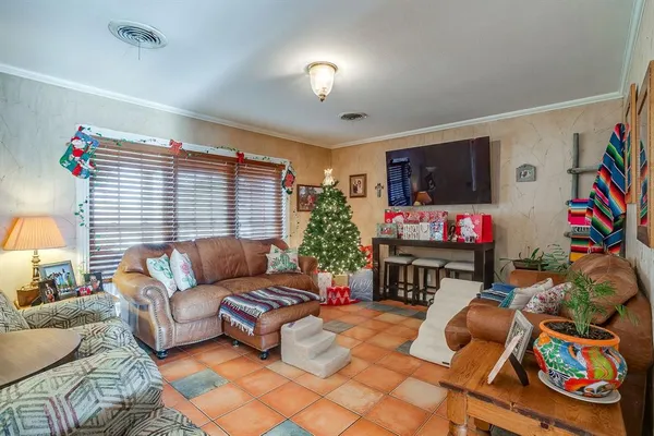 a living room with furniture a flat screen tv and a window