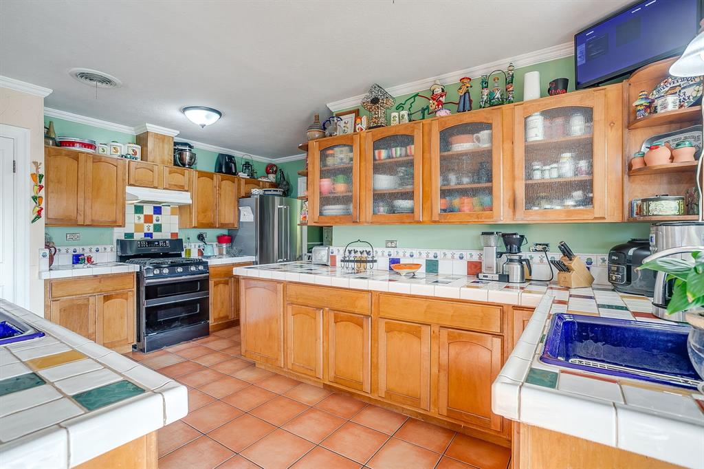 205 West Ridge Street Weatherford, TX 76086 - Photo 7 of 34 a kitchen with stainless steel appliances granite countertop a stove and cabinets