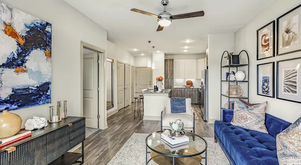 a living room with furniture kitchen view and a chandelier