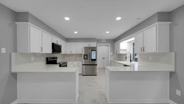 a large white kitchen with cabinets