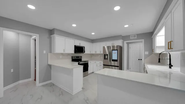 a kitchen with stainless steel appliances a refrigerator sink and microwave