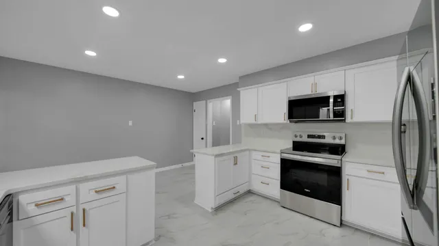 a kitchen with white cabinets stainless steel appliances and sink