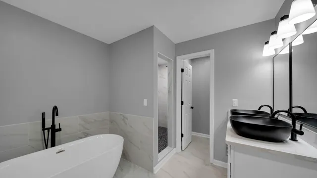 a bathroom with a sink a tub and a mirror