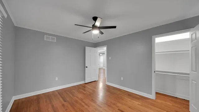 a view of a room with wooden floor and a ceiling fan
