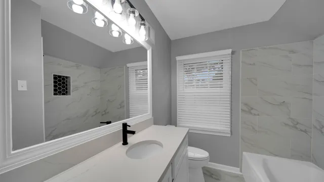 a bathroom with a sink a toilet and shower