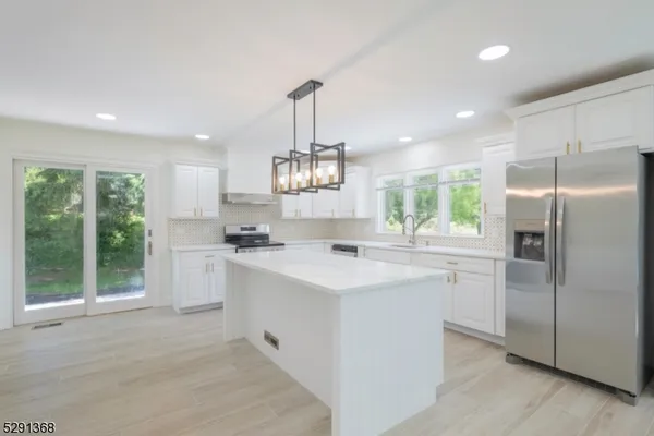a kitchen with kitchen island a sink appliances and cabinets