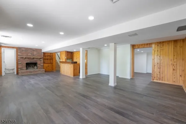 a view of empty room with wooden floor and fireplace