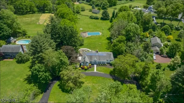 an aerial view of a house with swimming pool and outdoor seating