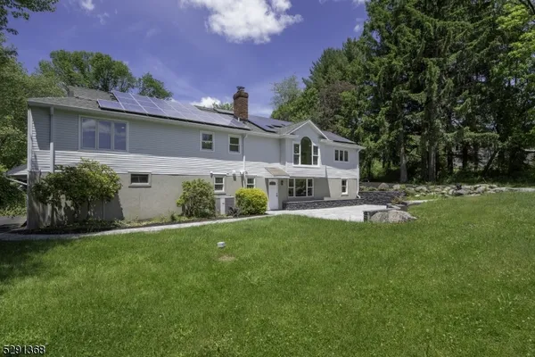 a front view of a house with a garden and trees