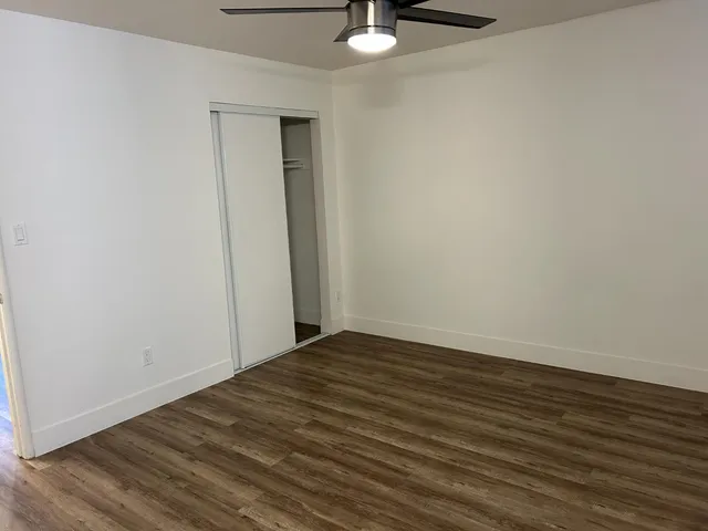 a view of an empty room with wooden floor