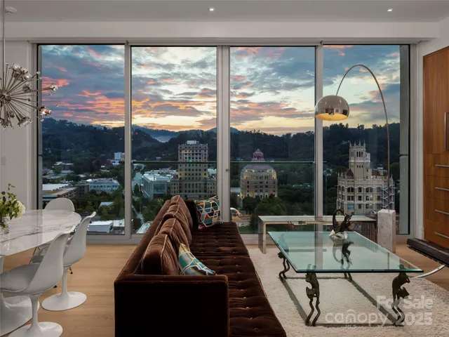 a living room with a floor to ceiling window and wooden floor