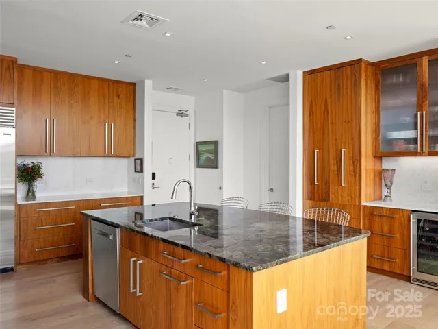 a kitchen with stainless steel appliances granite countertop a sink a counter space and cabinets