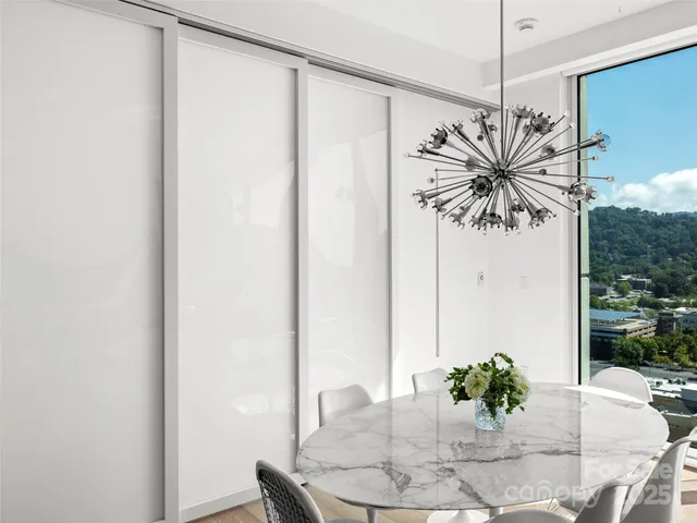 a dining room with furniture and a potted plant