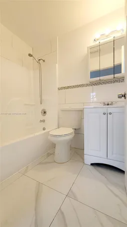 a bathroom with a granite countertop sink a toilet and bathtub
