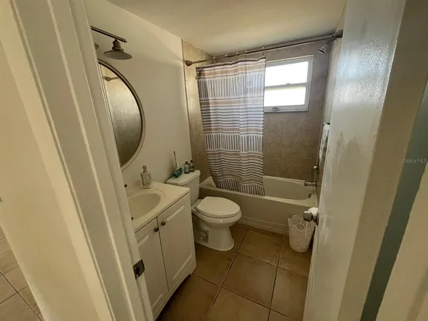 a bathroom with a granite countertop toilet a sink and a mirror
