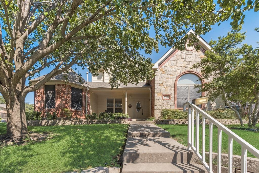View of front of property with a front lawn, stone siding, and a porch
