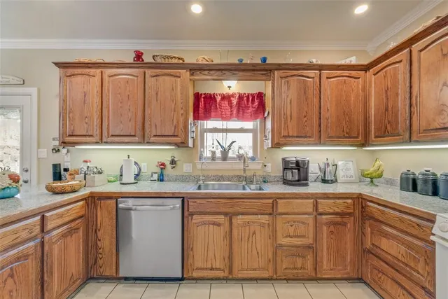 a kitchen with granite countertop a sink stainless steel appliances and cabinets