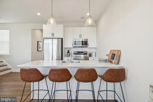 a kitchen with kitchen island a refrigerator stove and microwave