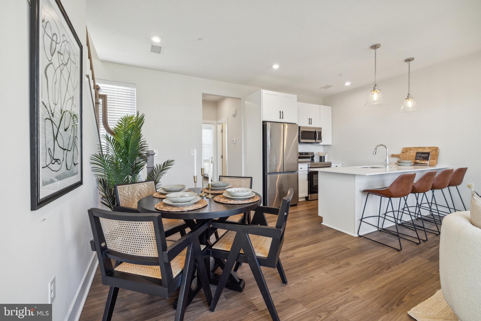 17 Mainland Road, Unit 216 Harleysville, PA 19438 - Photo 8 of 23 a kitchen with stainless steel appliances a dining table chairs and a refrigerator