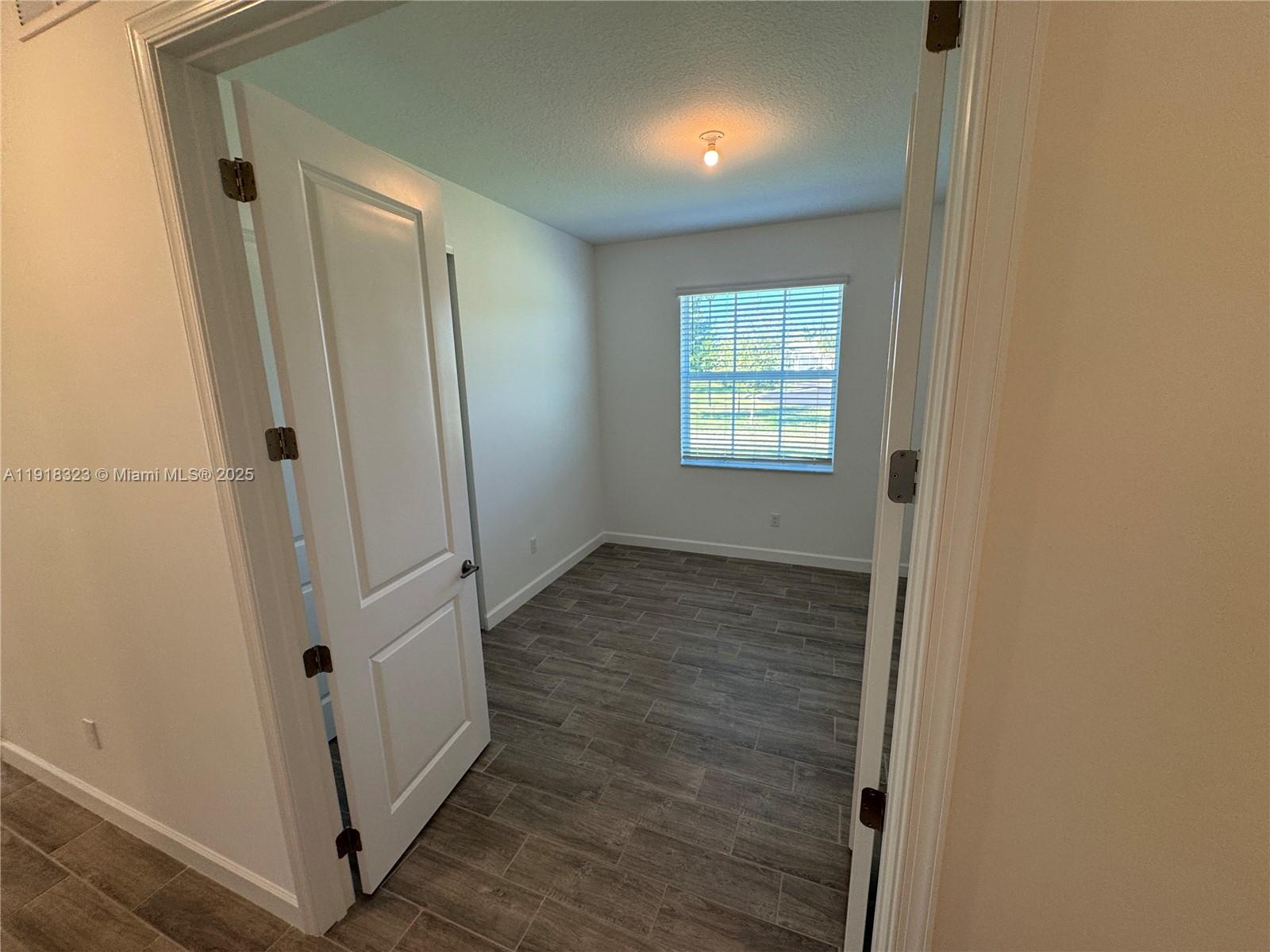 5726 Divine Drive, Unit 5726 Delray Beach, FL 33484 - Photo 11 of 44 a view of an empty room with wooden floor and a window