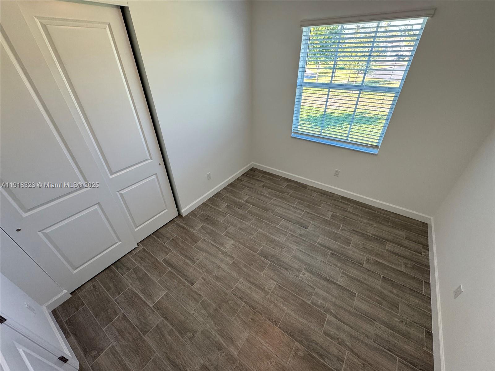 5726 Divine Drive, Unit 5726 Delray Beach, FL 33484 - Photo 12 of 44 an empty room with wooden floor and windows