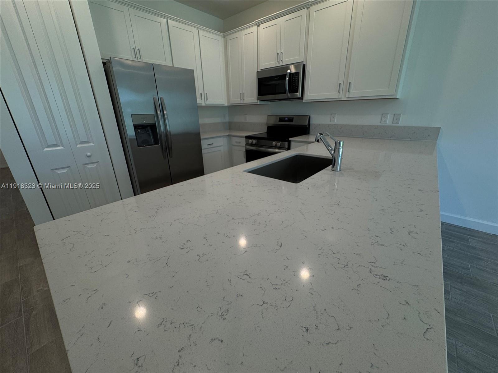 5726 Divine Drive, Unit 5726 Delray Beach, FL 33484 - Photo 19 of 44 a kitchen with stainless steel appliances a refrigerator a sink a stove a microwave and cabinets