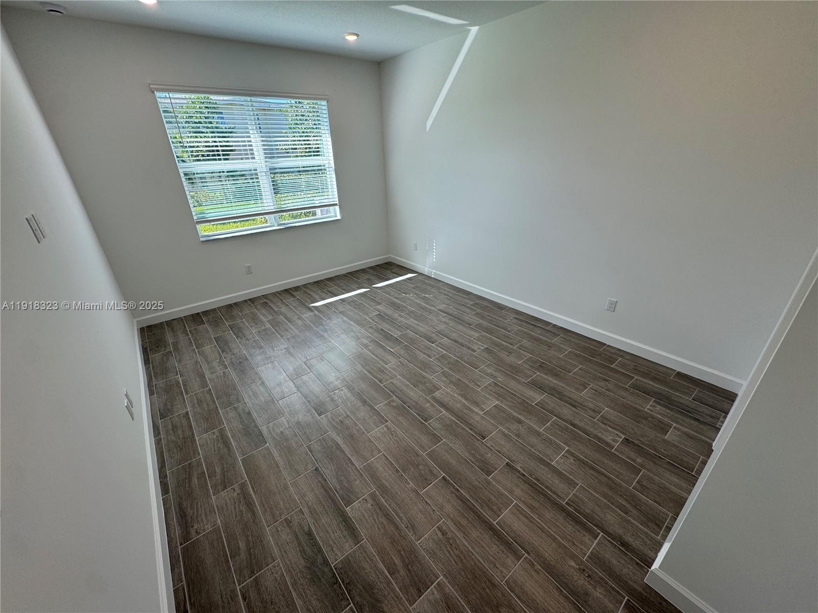 5726 Divine Drive, Unit 5726 Delray Beach, FL 33484 - Photo 26 of 44 an empty room with wooden floor and windows