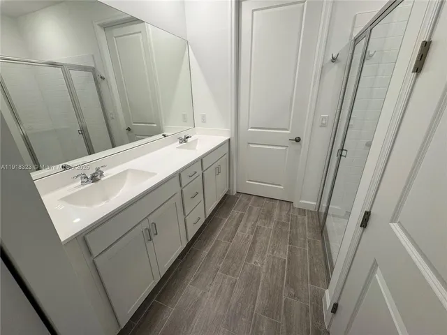 a bathroom with a glass shower door and a sink