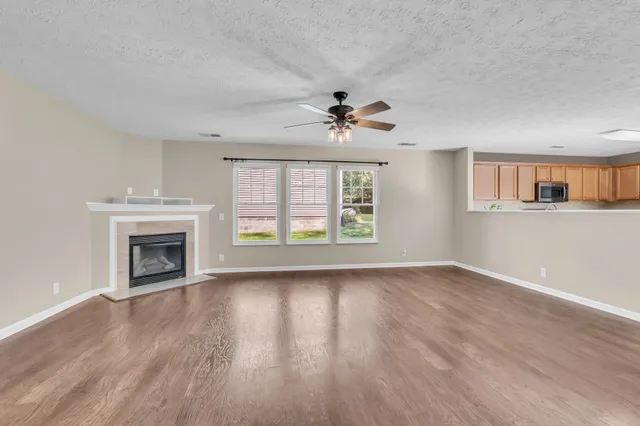 a view of an empty room with a window and fireplace