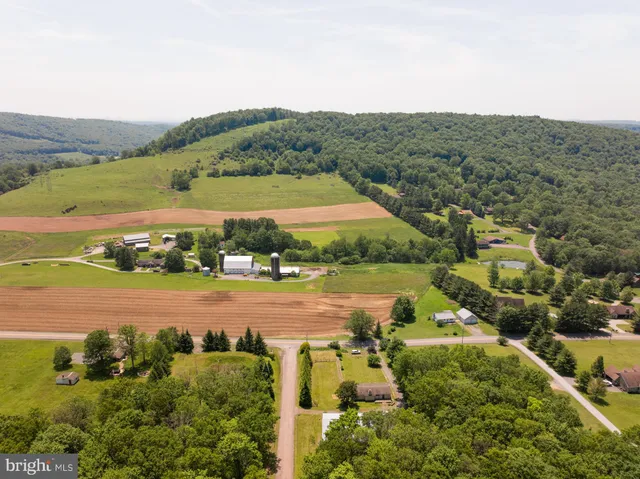 an aerial view of ocean and residential houses with outdoor space