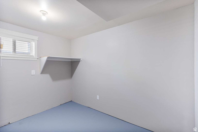 415 East 1150th Street North Logan, UT 84341 - Photo 27 of 38 Light-filled room featuring a single window with white trim, a built-in shelf, and blue-toned flooring