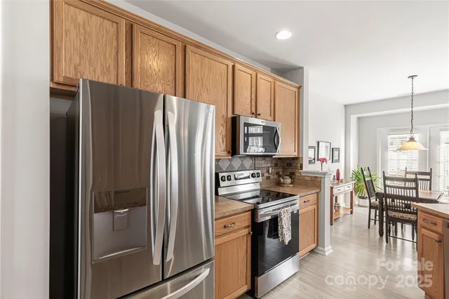 a kitchen with stainless steel appliances granite countertop a refrigerator stove and sink