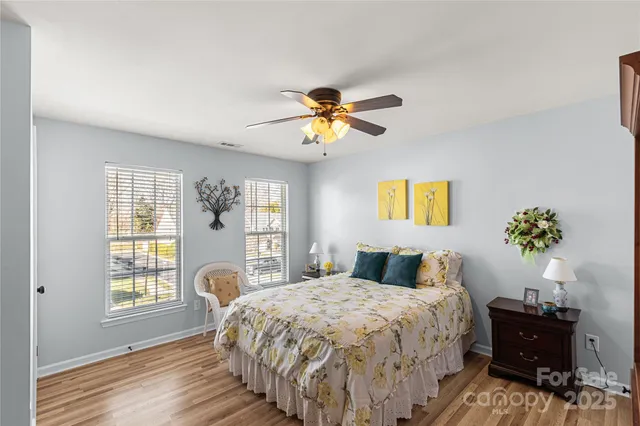 a bedroom with a bed and a potted plant on the dresser