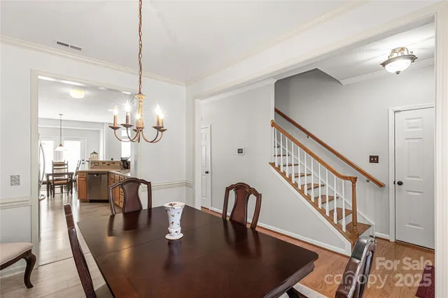 a dining room with furniture a chandelier and wooden floor