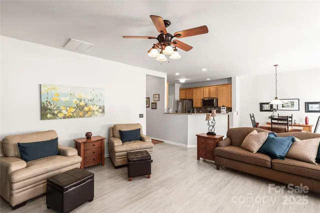 a living room with furniture kitchen view and a chandelier