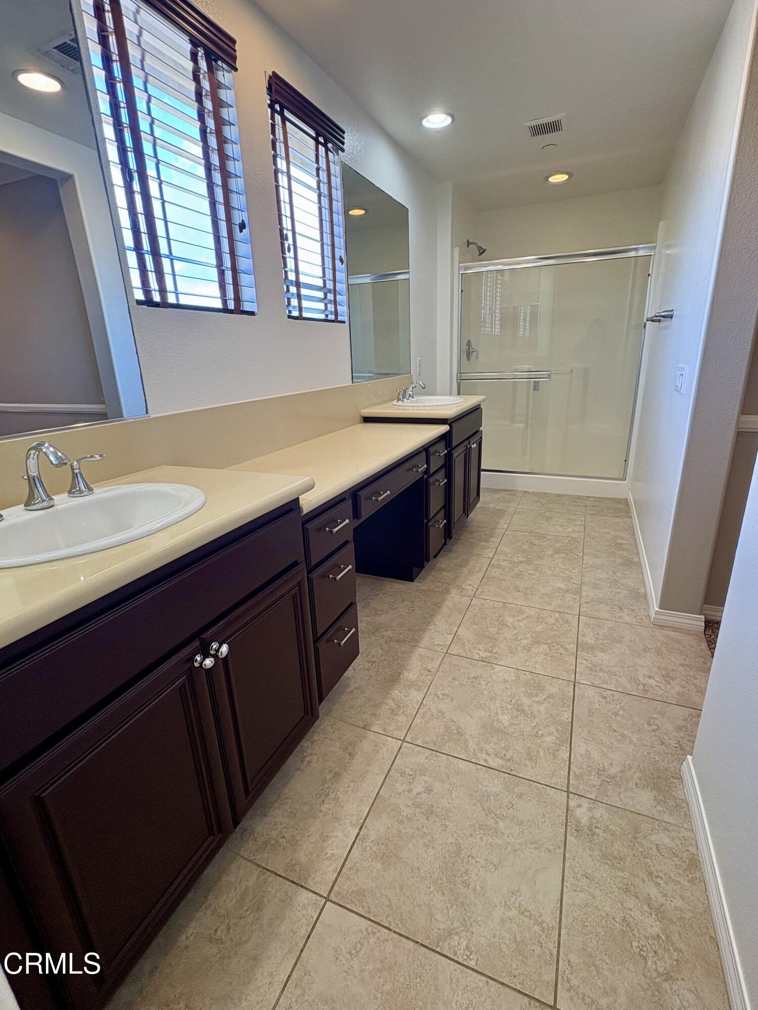 3151 Lisbon Lane Oxnard, CA 93036 - Photo 15 of 17 a spacious bathroom with a vanity a sink a mirror and a bathtub