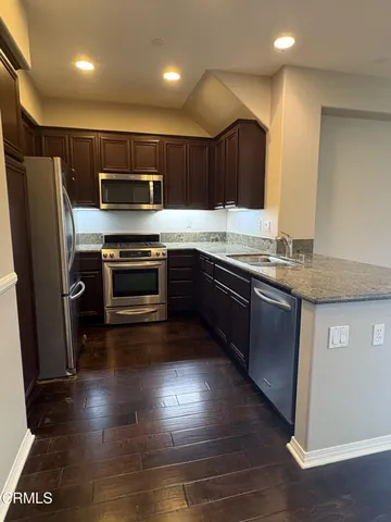 a kitchen with granite countertop a refrigerator and a stove