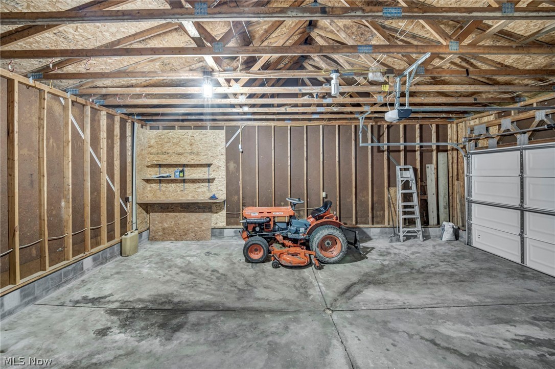 2642 Blake Road Wadsworth, OH 44281 - Photo 35 of 50 Concrete flooring, exposed wood framing, built-in shelving, and a garage door with an automatic opener