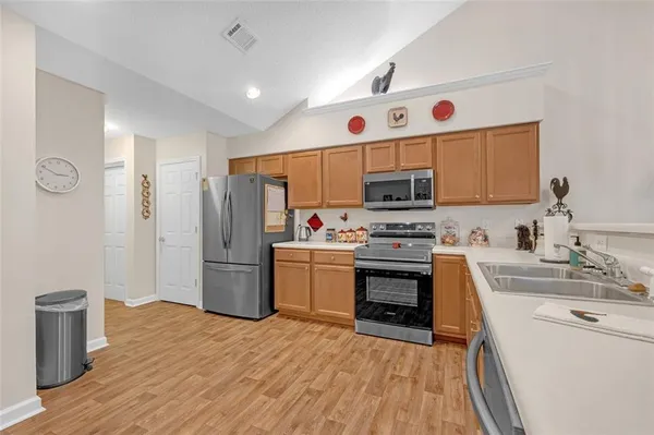 a kitchen with a refrigerator microwave and stove top oven