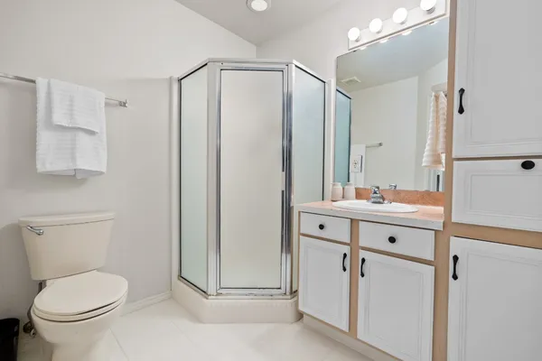 a bathroom with a toilet a sink a mirror and vanity