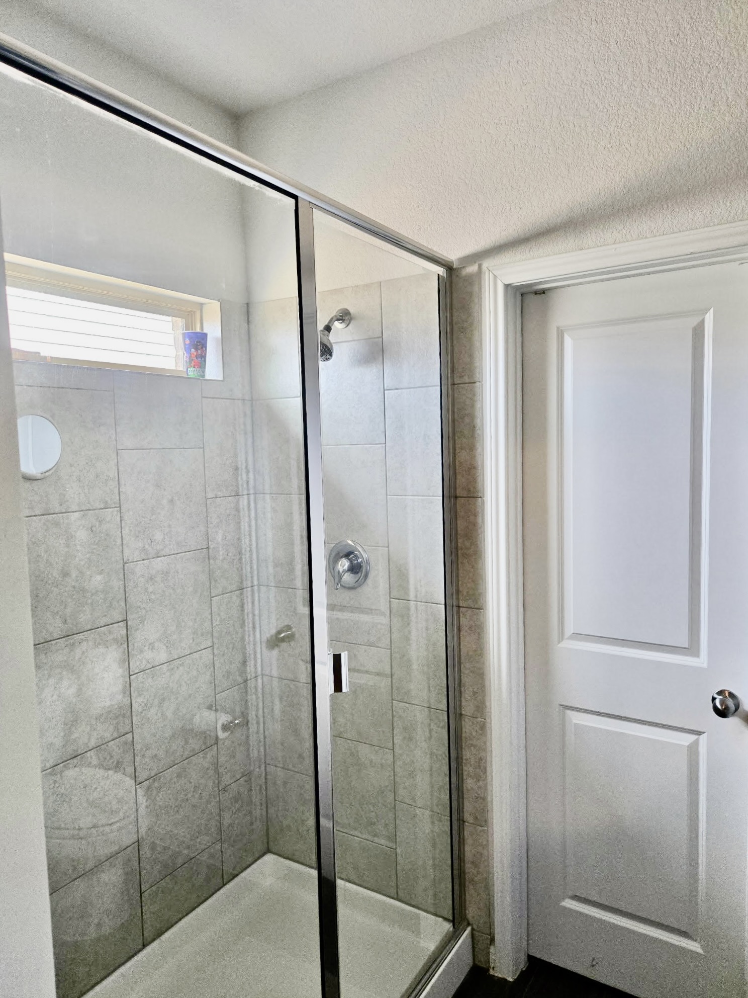 140 Pentro Path Georgetown, TX 78626 - Photo 11 of 37 A well-lit, tiled shower with a clear glass enclosure and sleek fixtures offers a refreshing experience.