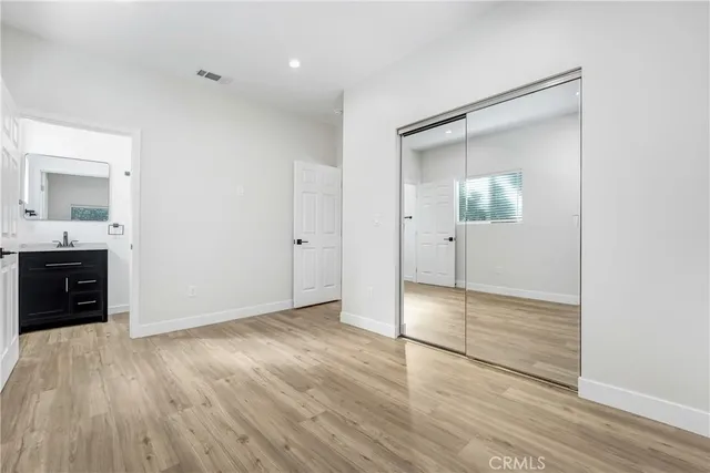 an empty room with wooden floor and mirror